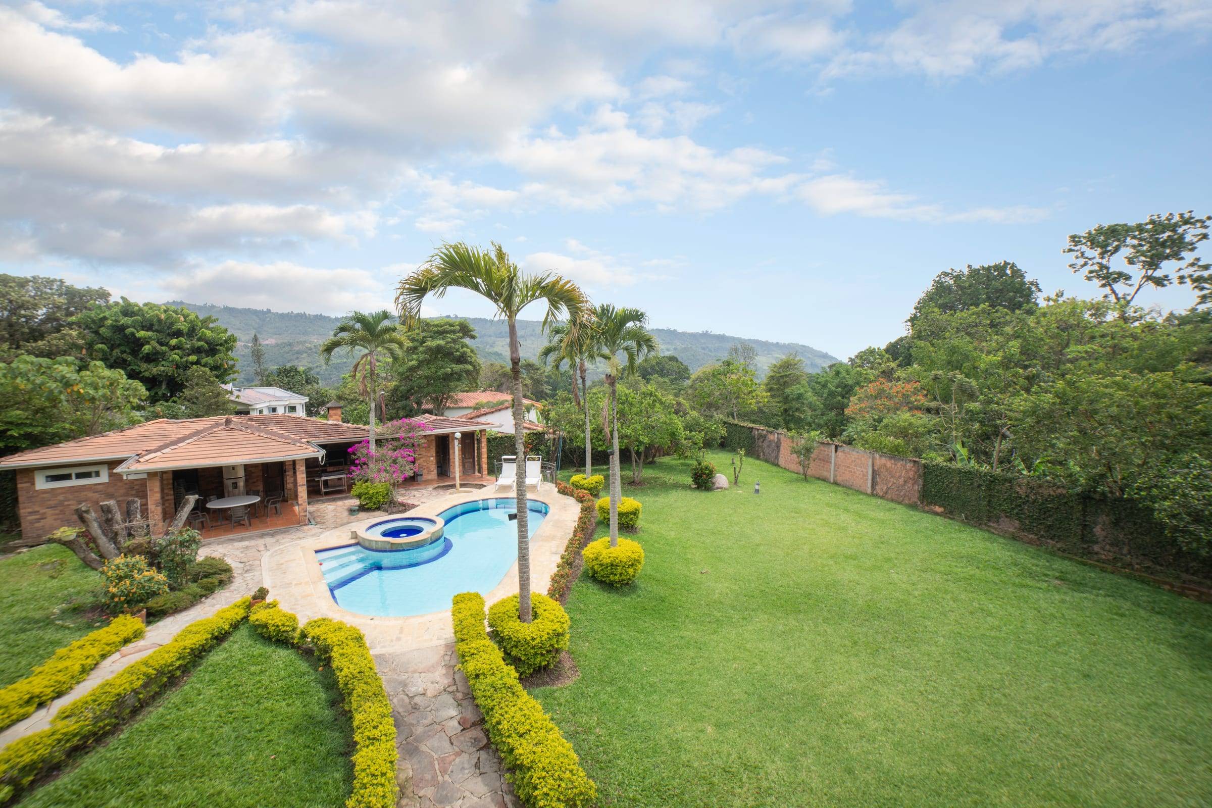 Vista de la piscina, el jardín y las montañas